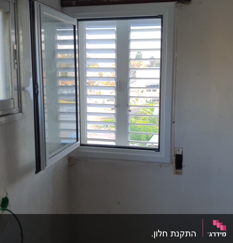 חלון אלומיניום פתוח עם תריסים לבנים